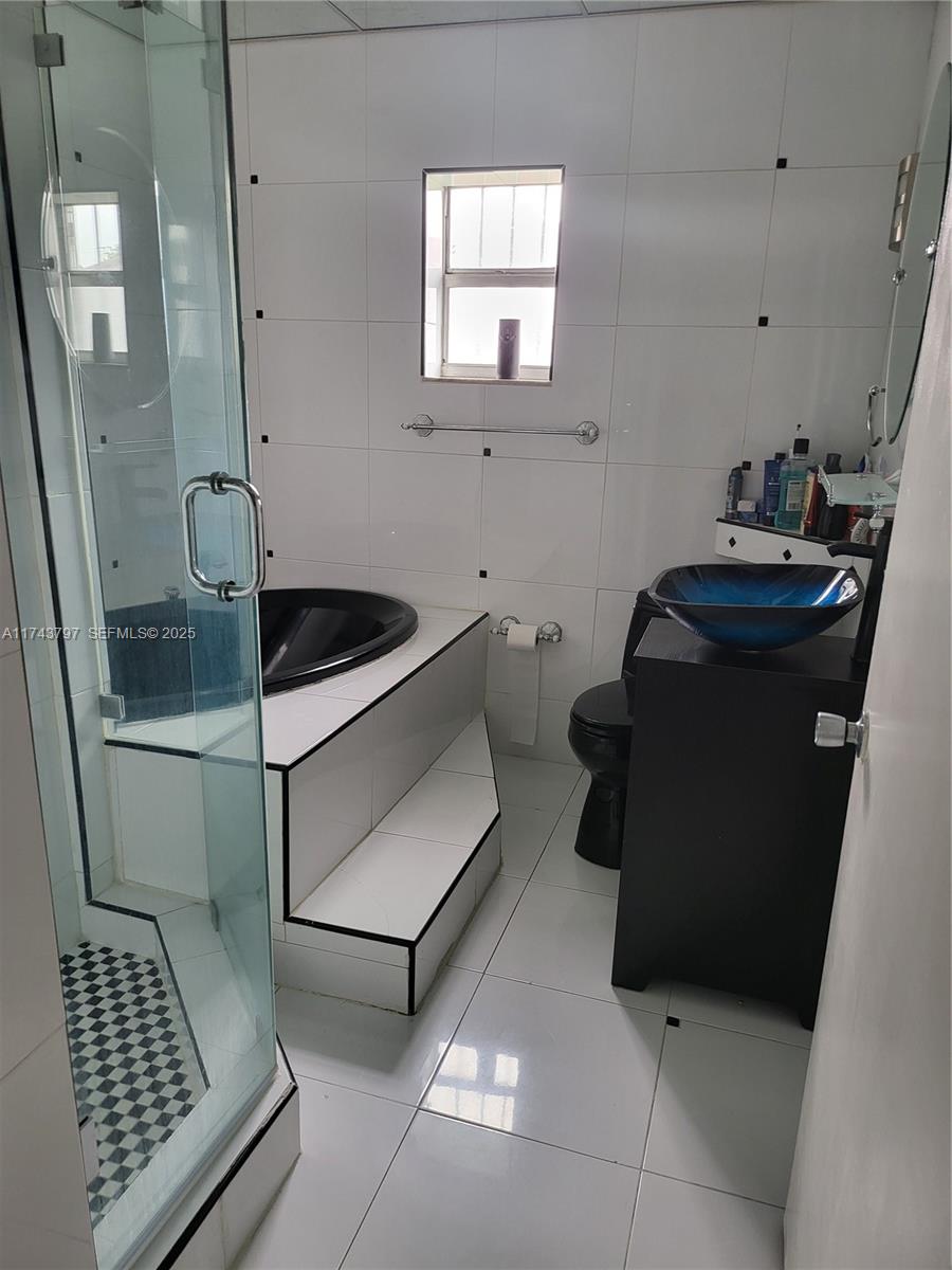 6771 Northwest 199th Terrace Hialeah, FL 33015 - Photo 20 of 42 a bathroom with a sink a toilet and mirror