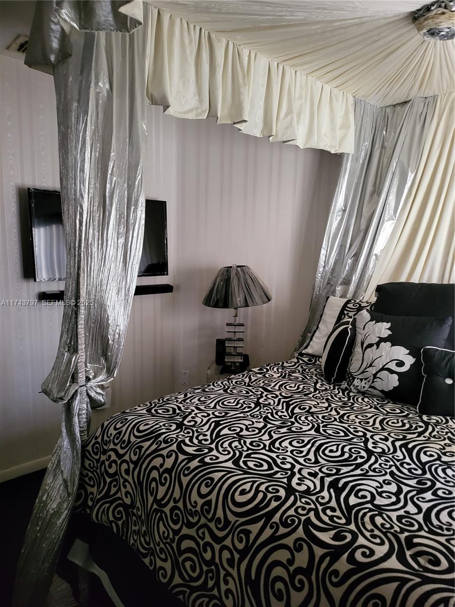 6771 Northwest 199th Terrace Hialeah, FL 33015 - Photo 30 of 42 a bedroom with a bed and chair