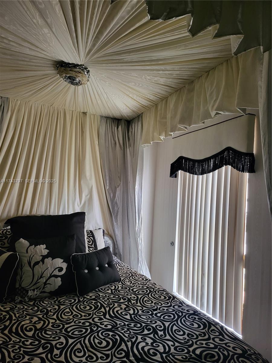 6771 Northwest 199th Terrace Hialeah, FL 33015 - Photo 32 of 42 a bedroom with a bed and a window