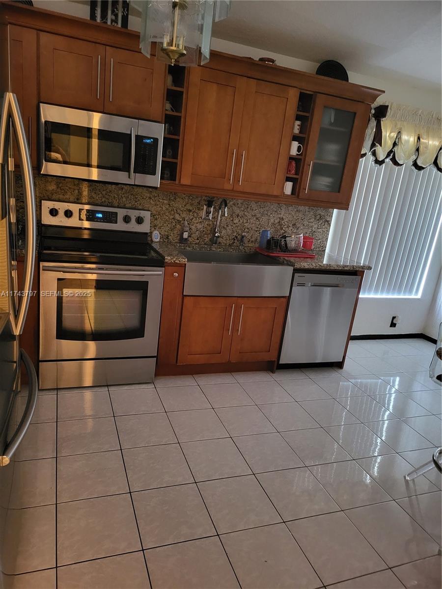 6771 Northwest 199th Terrace Hialeah, FL 33015 - Photo 33 of 42 a kitchen with stainless steel appliances granite countertop a stove a microwave and a sink