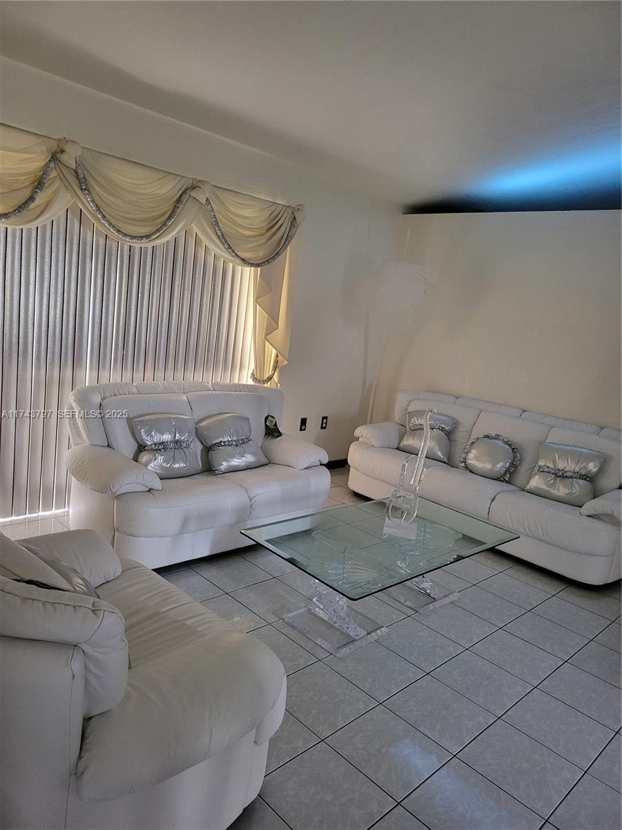 6771 Northwest 199th Terrace Hialeah, FL 33015 - Photo 6 of 42 a bedroom with a bed and a couch