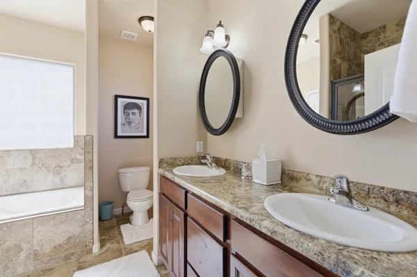 a bathroom with a granite countertop double vanity sinks and a mirror