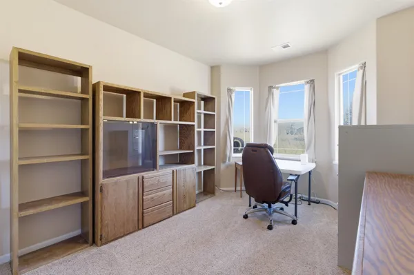 a view of a workspace with furniture and a window