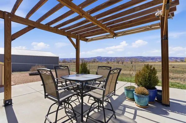 a view of an outdoor dining space with furniture and garden view
