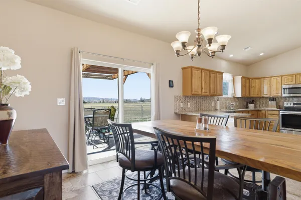 a view of a dining room with furniture a chandelier and wooden floor