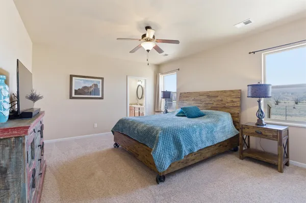 a spacious bedroom with a bed and a chandelier