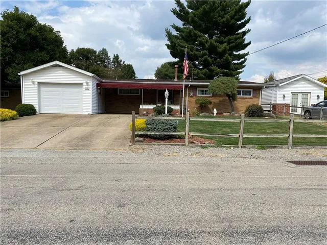 a view of a house with a backyard and a garage