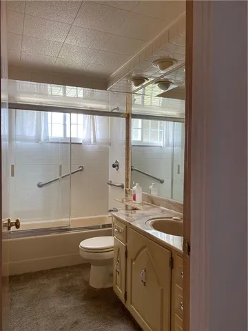 a bathroom with a double vanity sink toilet mirror and bathtub