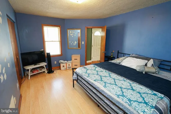 a bedroom with a bed a couch and a flat screen tv