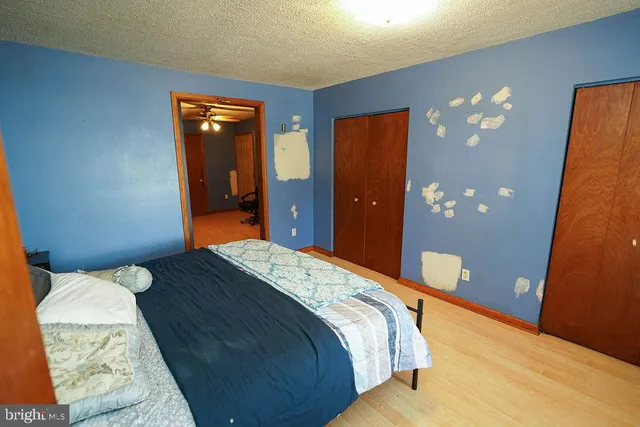 a bedroom with a bed a couch and a flat screen tv