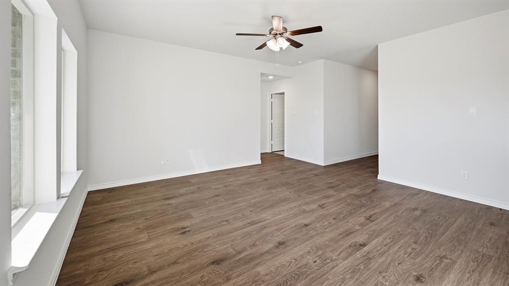 419 Epiphany Lane Lavon, TX 75166 - Photo 11 of 31 Spacious room featuring wood-finish flooring, white walls, and a ceiling fan