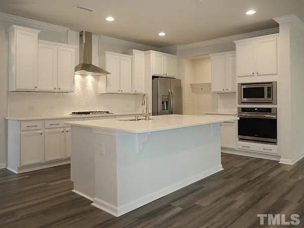 a kitchen with kitchen island white cabinets and stainless steel appliances