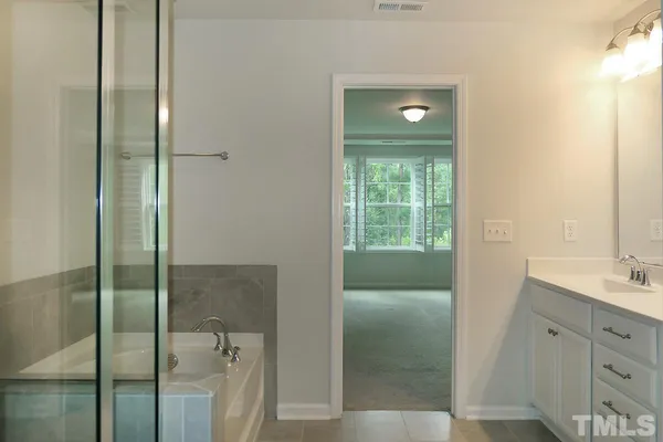 a bathroom with a shower sink and mirror
