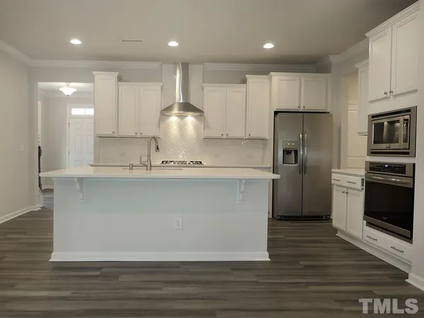 a large kitchen with stainless steel appliances granite countertop a stove a sink and a refrigerator