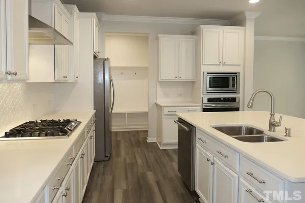 a kitchen with granite countertop a sink stove and refrigerator