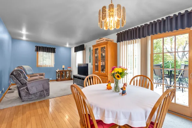 a dining room with furniture a chandelier and wooden floor