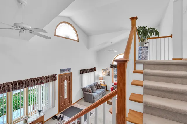 a view of staircase with railing and white walls