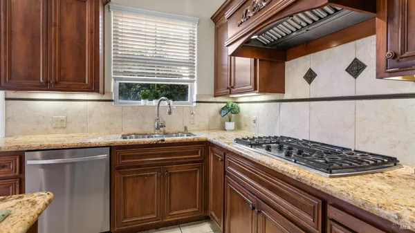 a kitchen with stainless steel appliances granite countertop a sink stove and cabinets