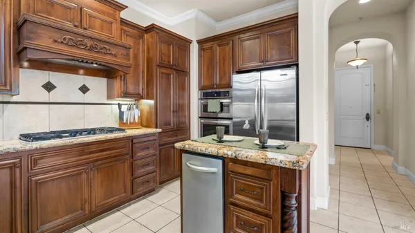 a kitchen with stainless steel appliances granite countertop a stove a refrigerator and a cabinets