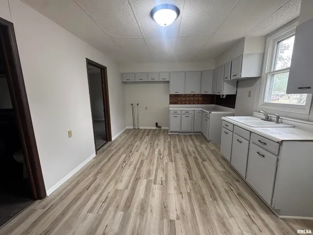 a kitchen with cabinets a sink and wooden floor