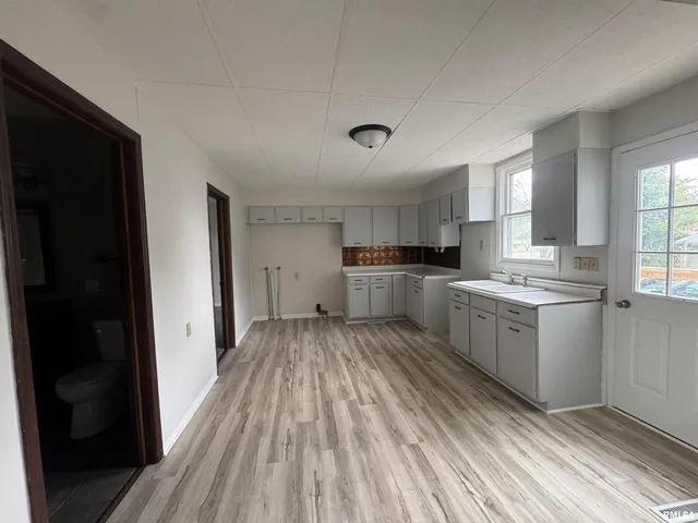 a kitchen with a refrigerator and wooden floor