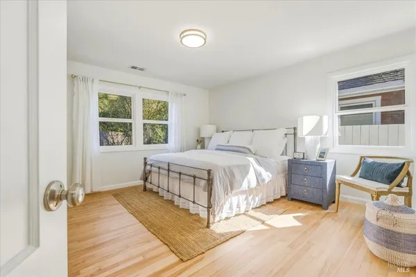a bedroom with a bed and wooden floor