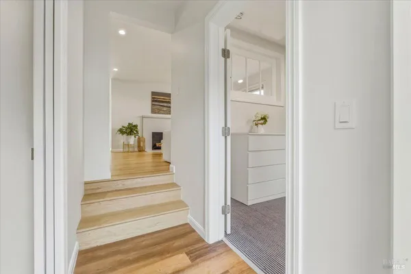 a view of a hallway with wooden floor and entryway