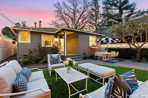 a view of a patio with couches table and chairs and potted plants