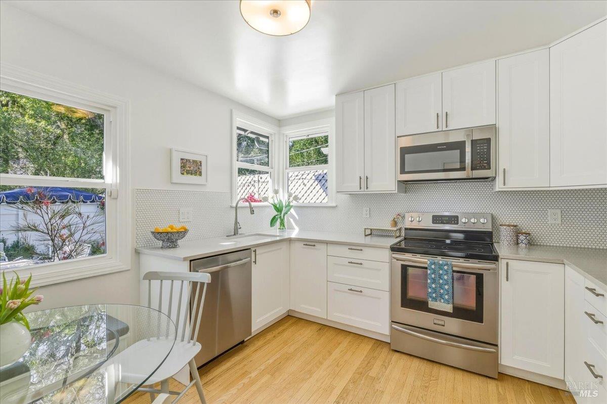 250 Butterfield Road San Anselmo, CA 94960 - Photo 9 of 28 a kitchen with stainless steel appliances granite countertop a stove a sink and a microwave