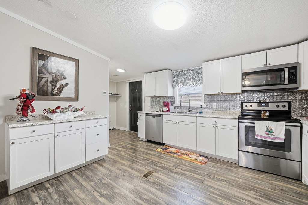 194 Burgess Road Ellijay, GA 30540 - Photo 7 of 32 a kitchen with stainless steel appliances white cabinets a sink and a stove