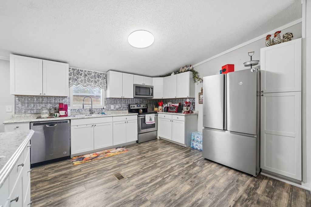 194 Burgess Road Ellijay, GA 30540 - Photo 8 of 32 a kitchen with granite countertop stainless steel appliances and white cabinets
