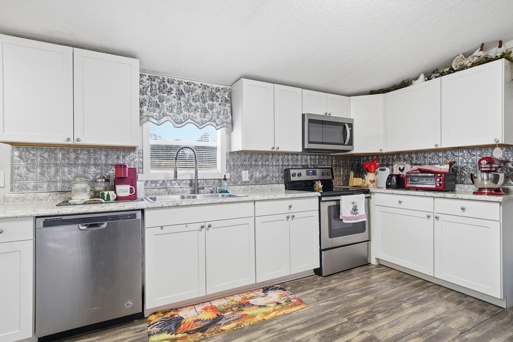 194 Burgess Road Ellijay, GA 30540 - Photo 9 of 32 a kitchen with stainless steel appliances granite countertop a sink stove and cabinets