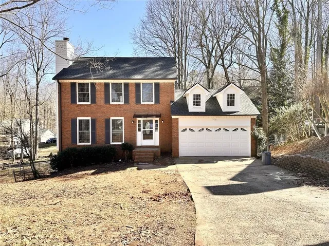 a front view of a house with a yard covered in snow