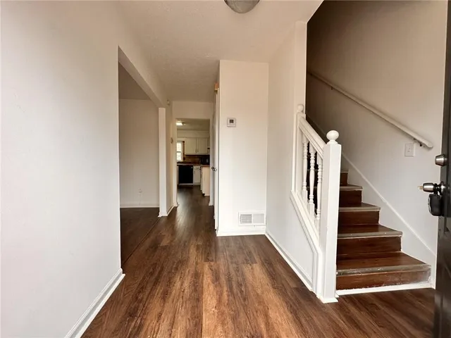 a view of a hallway with wooden floor and staircase