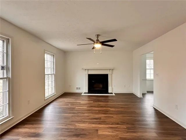 an empty room with windows and a fireplace