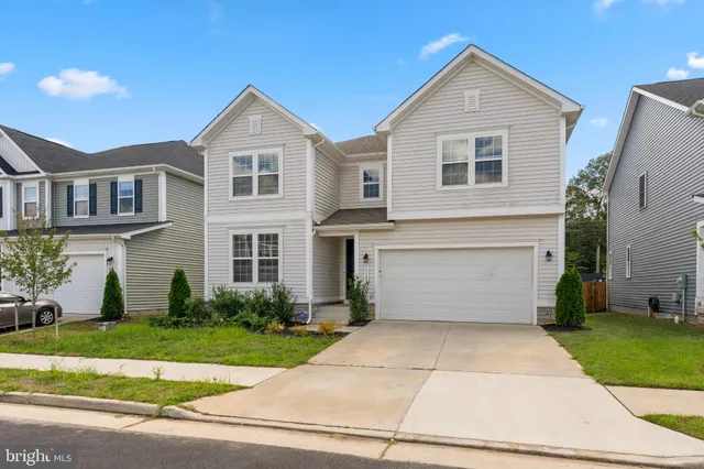 a front view of a house with a yard and a garage