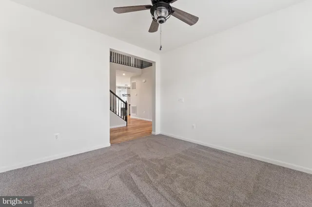 a view of a hallway with a chandelier fan and windows