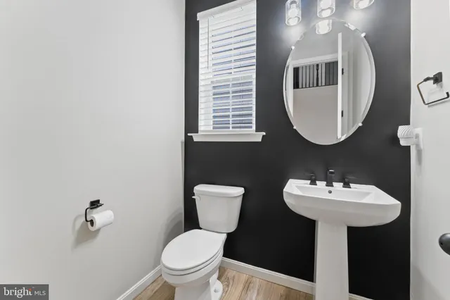 a bathroom with a sink toilet and a mirror