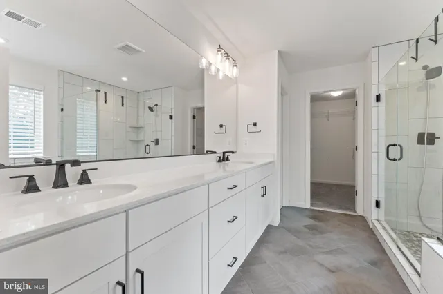 a bathroom with double sink and a mirror