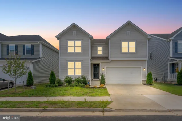 a front view of a house with a yard and a garage