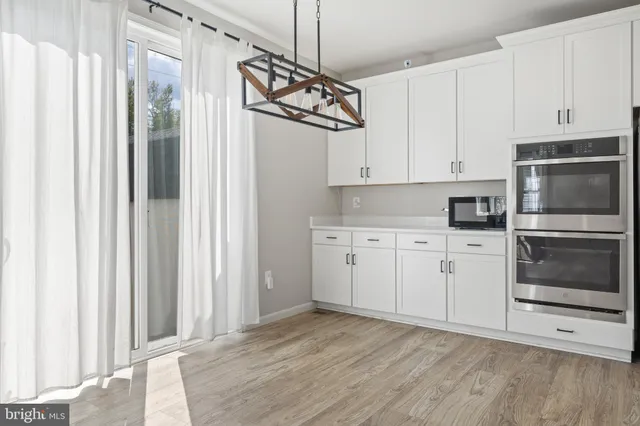 a kitchen with white cabinets and black appliances