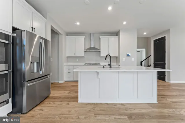 a kitchen with white cabinets and stainless steel appliances