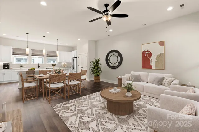 a living room with lots of furniture and view of kitchen