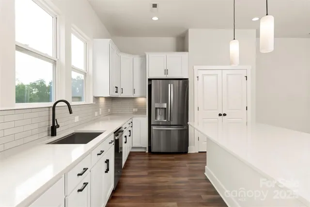 a kitchen with white cabinets and refrigerator