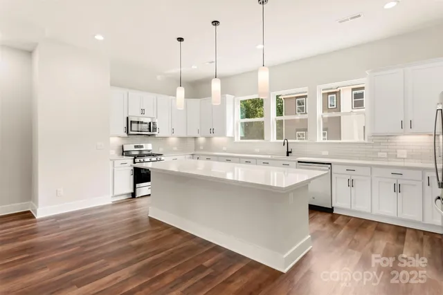 a kitchen with a sink window and stainless steel appliances