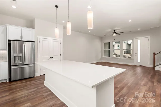 a large kitchen with kitchen island white cabinets and stainless steel appliances