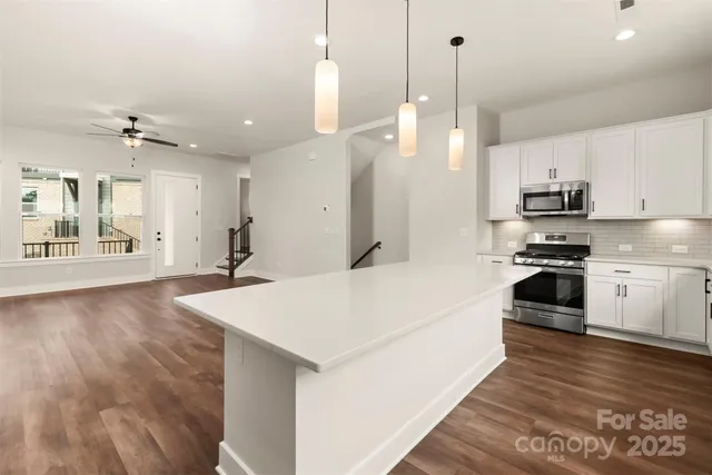 a large white kitchen with stainless steel appliances
