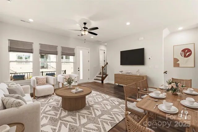 a living room with furniture a flat screen tv and a large window