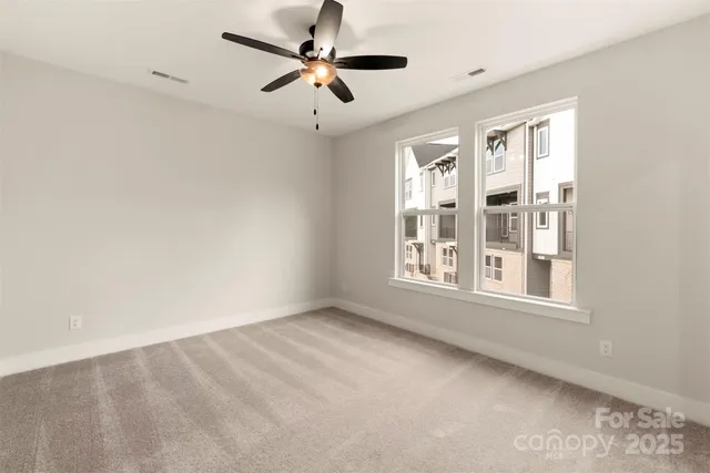 an empty room with a window and a fan