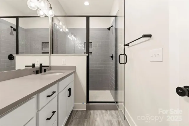 a bathroom with a shower sink and mirror